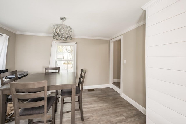 11 Post Rd, North Hampton, NH 03862 - dining area with baseboards, wood finished floors, ornamental molding, and a chandelier