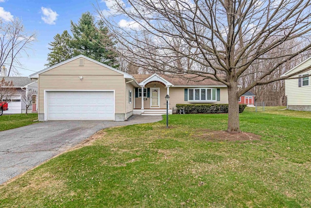 ranch-style home featuring driveway, a front yard, and a garage