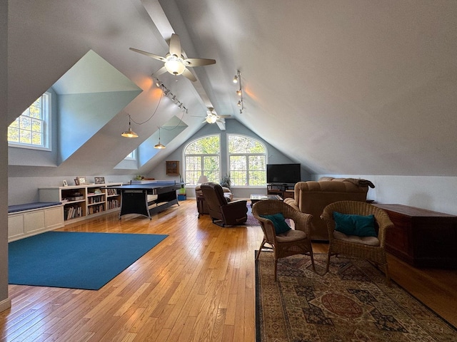 interior space featuring a ceiling fan, vaulted ceiling, and light wood-style flooring