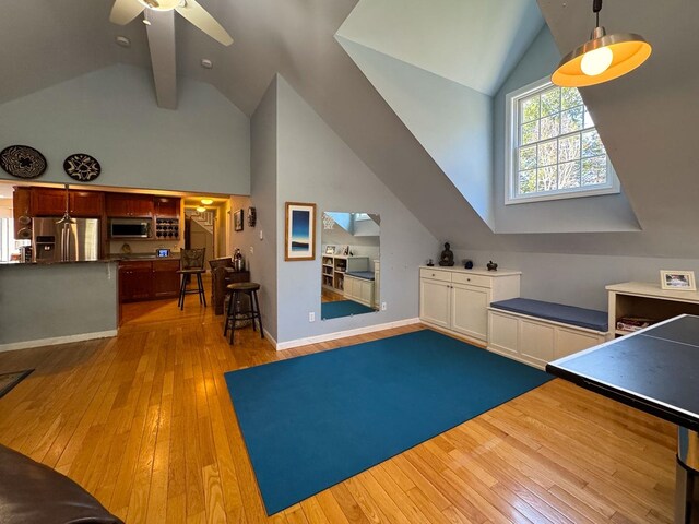 interior space featuring high vaulted ceiling, baseboards, a ceiling fan, and hardwood / wood-style floors