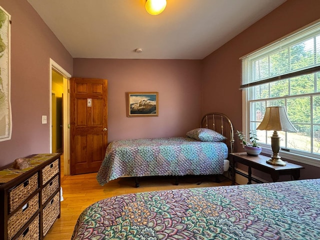 bedroom with light wood-style floors and multiple windows
