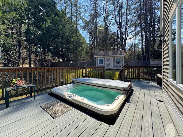 wooden terrace featuring a covered hot tub, an outbuilding, a fenced backyard, and a storage shed