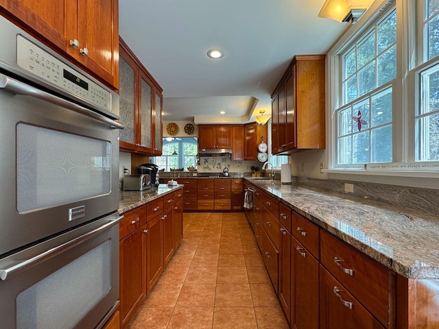 kitchen with light tile patterned floors, stainless steel double oven, a sink, and recessed lighting