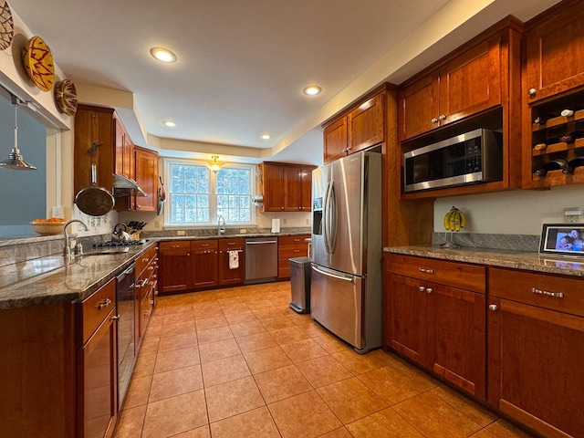 kitchen featuring dark stone counters, stainless steel appliances, light tile patterned flooring, and a sink