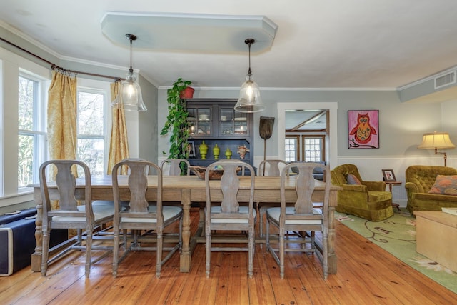 dining space featuring a wainscoted wall, a wealth of natural light, wood-type flooring, and visible vents