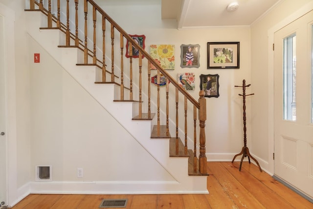 foyer entrance featuring visible vents, baseboards, wood finished floors, and stairway