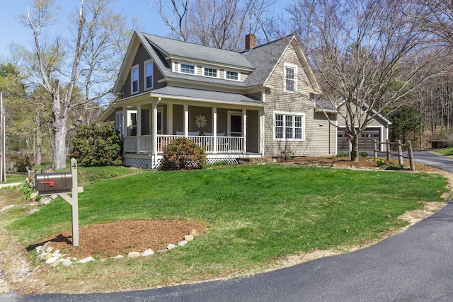 view of front of house with a shingled roof, a porch, a front yard, a chimney, and driveway