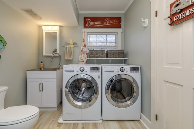 washroom with laundry area, visible vents, light wood finished floors, ornamental molding, and washer and dryer