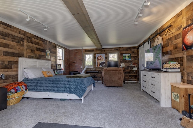 bedroom featuring track lighting, light carpet, and wood walls