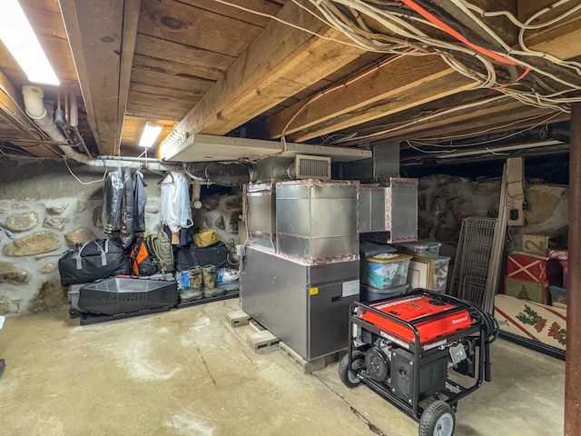unfinished basement with visible vents and heating unit