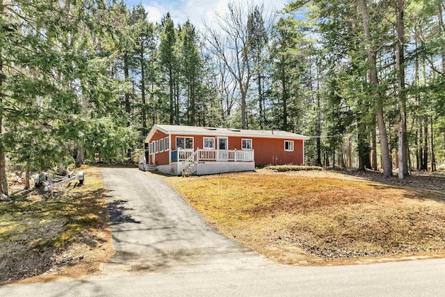 ranch-style house with a porch and aphalt driveway