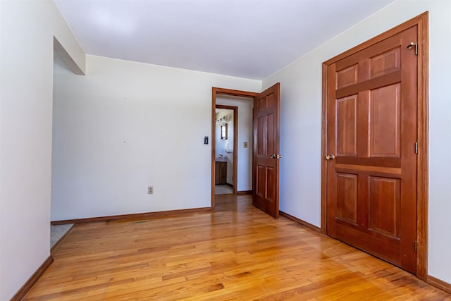 empty room featuring baseboards and light wood-style flooring