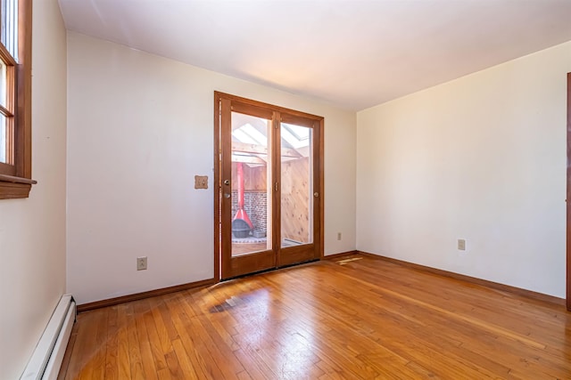 unfurnished room featuring baseboards, a baseboard radiator, and light wood-style flooring