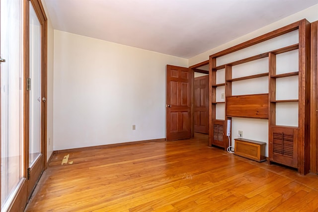 interior space with baseboards and light wood finished floors
