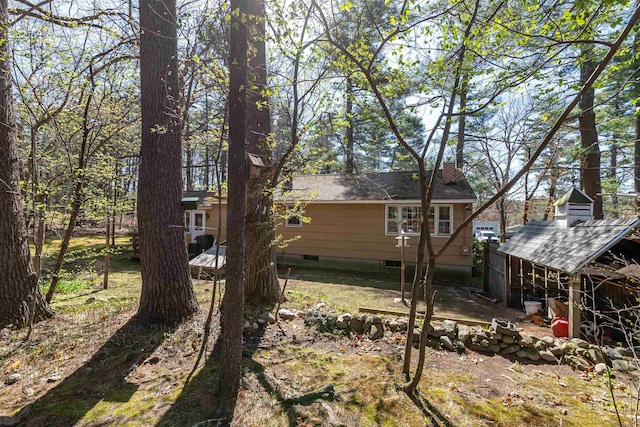 rear view of property with crawl space and a chimney