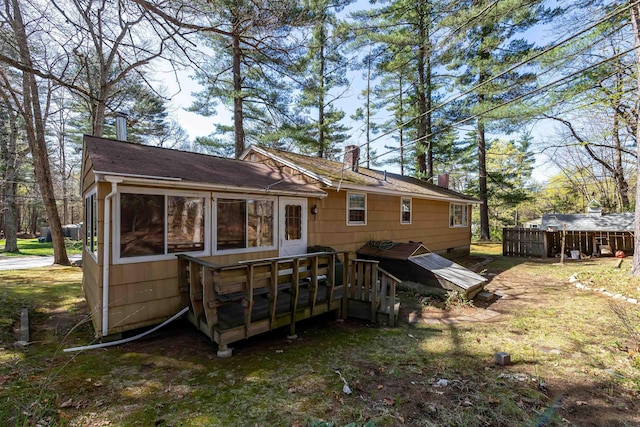 rear view of house with a chimney and a deck