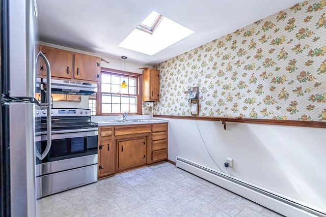 kitchen featuring brown cabinets, appliances with stainless steel finishes, wallpapered walls, a skylight, and a baseboard heating unit
