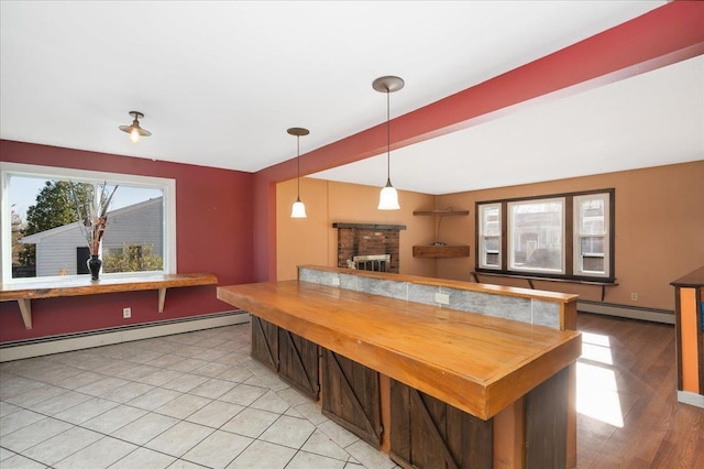 kitchen featuring butcher block countertops, a baseboard heating unit, and decorative light fixtures