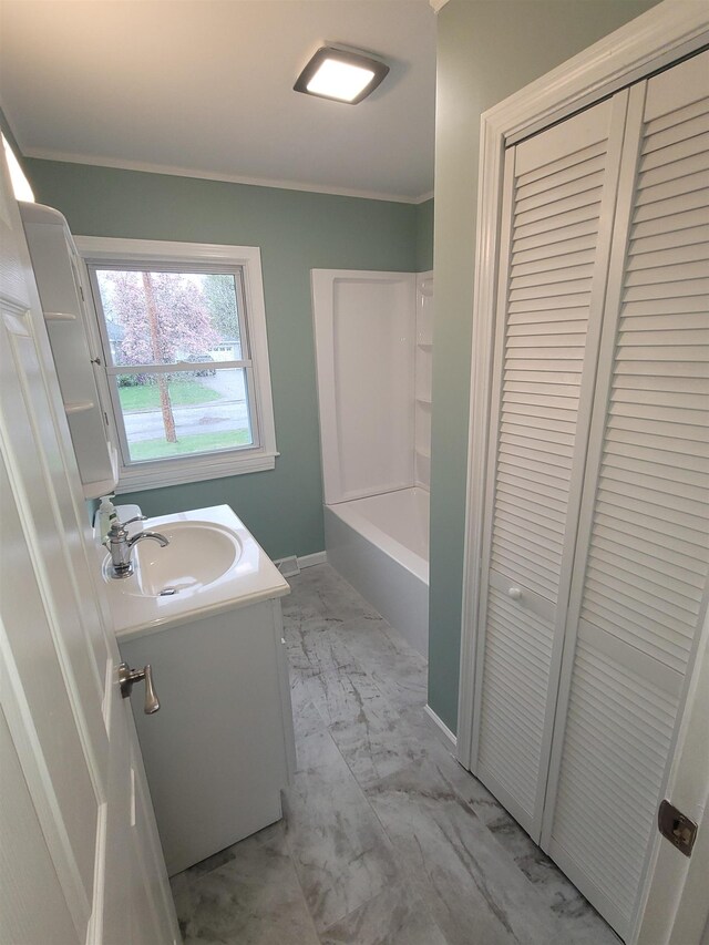 bathroom featuring vanity, ornamental molding, marble finish floor, and a closet