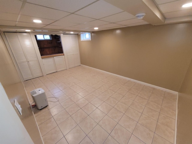 below grade area with light tile patterned floors, baseboards, recessed lighting, and a paneled ceiling