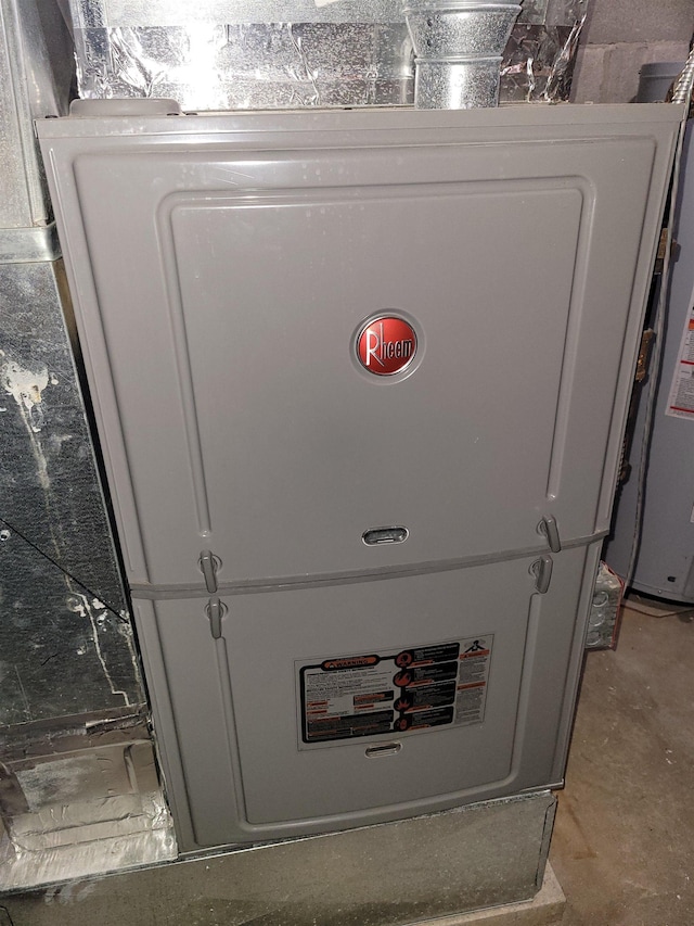 utility room featuring heating unit and water heater