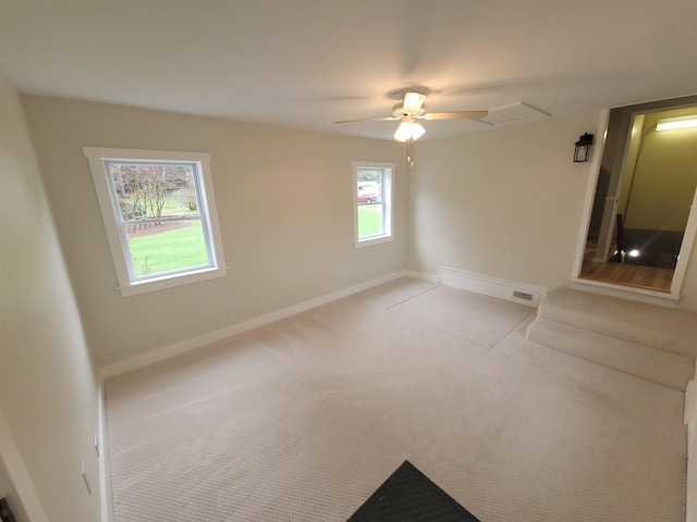 carpeted spare room featuring baseboards and ceiling fan