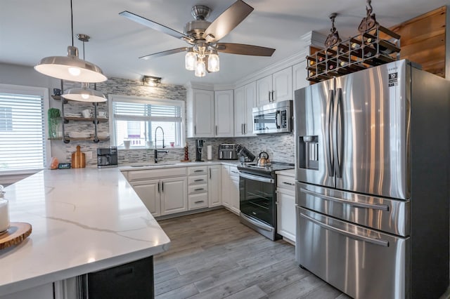 kitchen with a sink, a ceiling fan, stainless steel appliances, and backsplash