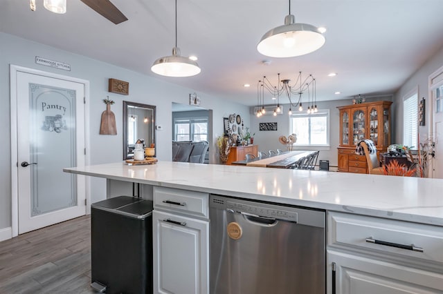 kitchen featuring stainless steel dishwasher, white cabinets, light stone counters, and wood finished floors