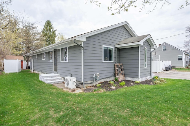 exterior space featuring fence, ac unit, and a yard