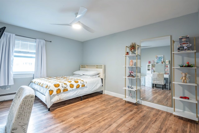 bedroom featuring baseboards, a ceiling fan, a baseboard heating unit, and wood finished floors