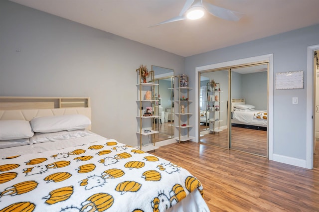 bedroom with a closet, baseboards, ceiling fan, and wood finished floors