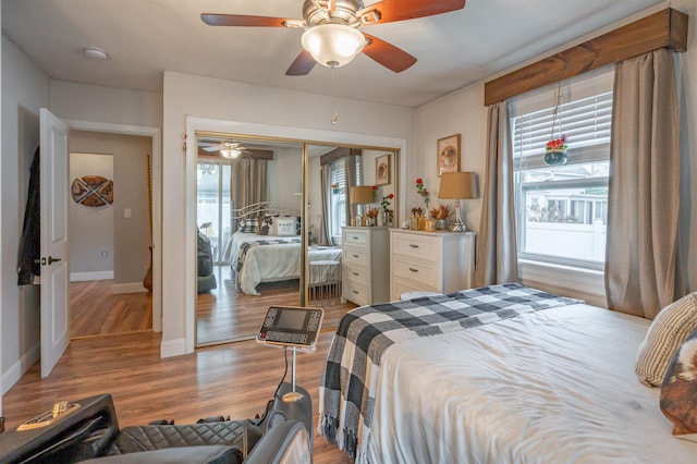 bedroom featuring baseboards, multiple windows, and wood finished floors