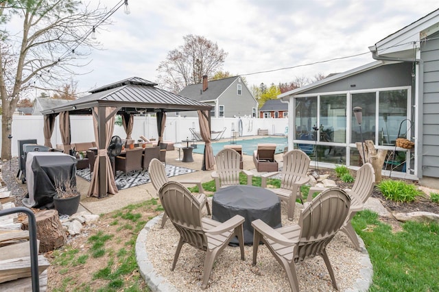 view of patio with a sunroom, a fenced backyard, a fenced in pool, and a gazebo