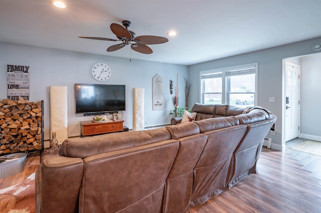 living area featuring a ceiling fan, wood finished floors, baseboards, a baseboard radiator, and recessed lighting
