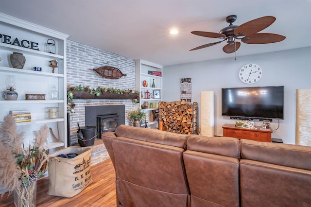 living area featuring a ceiling fan, built in shelves, and wood finished floors