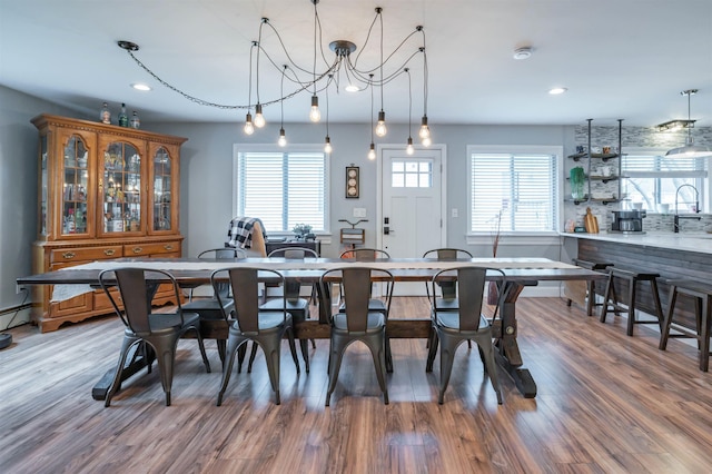 dining area with recessed lighting, an inviting chandelier, and light wood-style floors