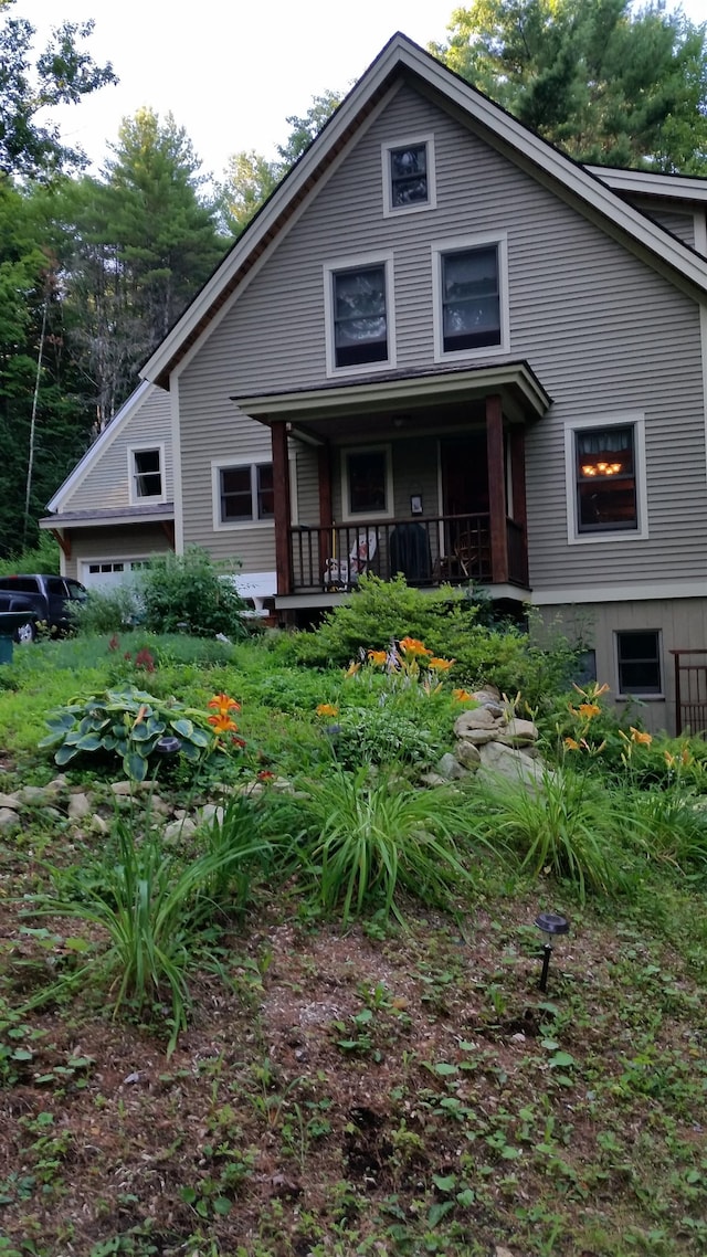 back of property with a garage and a porch