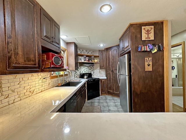 kitchen with open shelves, decorative backsplash, light countertops, a sink, and black appliances