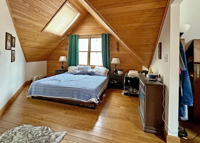 bedroom with wood walls, wooden ceiling, lofted ceiling with skylight, and light wood-style floors