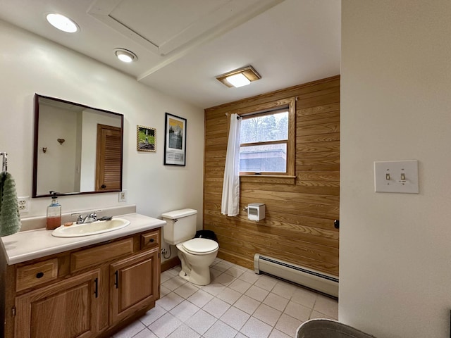 bathroom with vanity, toilet, wood walls, and a baseboard radiator