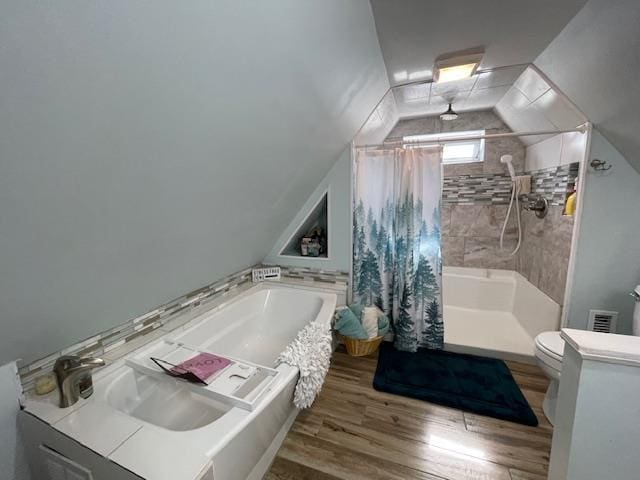 full bath featuring wood finished floors, a bathing tub, toilet, and a shower with curtain