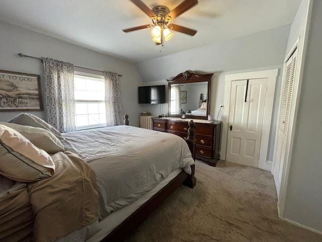 carpeted bedroom with ceiling fan and vaulted ceiling