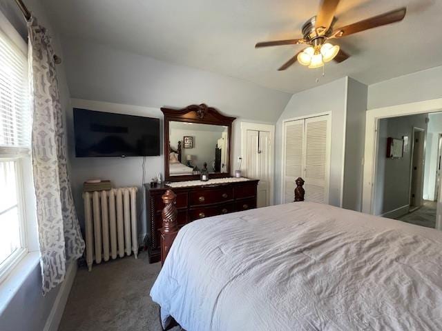 carpeted bedroom with radiator, ceiling fan, and vaulted ceiling