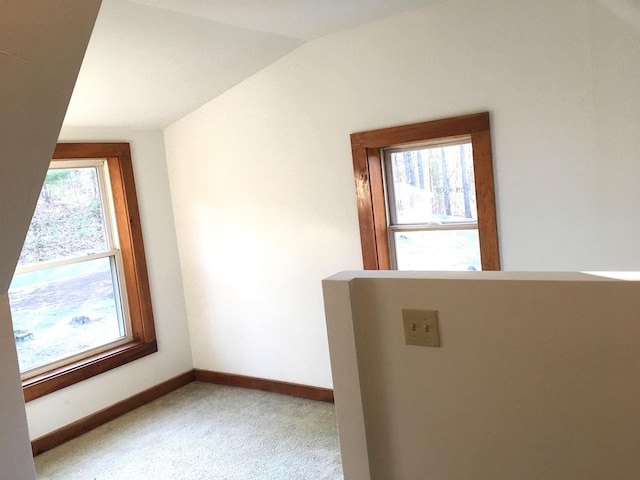 carpeted empty room with baseboards and lofted ceiling