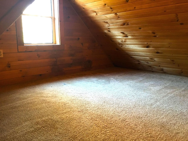 bonus room featuring carpet floors, wood walls, wooden ceiling, and lofted ceiling
