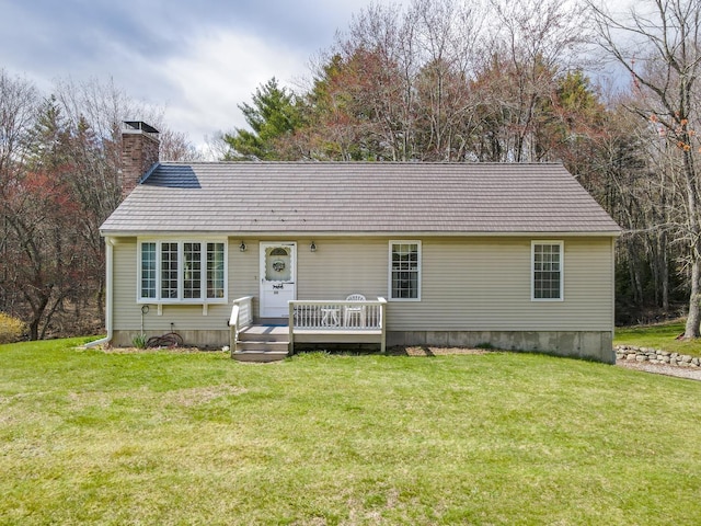 ranch-style home with a chimney, a deck, and a front yard
