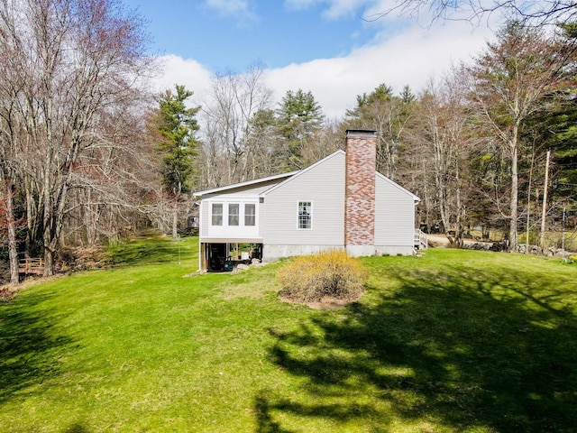 back of property featuring a yard and a chimney