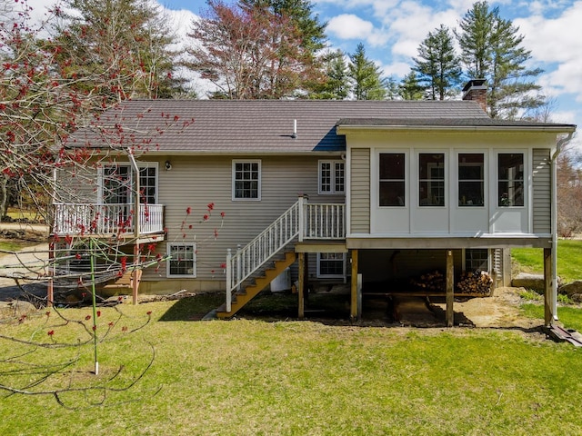 rear view of house featuring a wooden deck, stairs, a chimney, and a yard