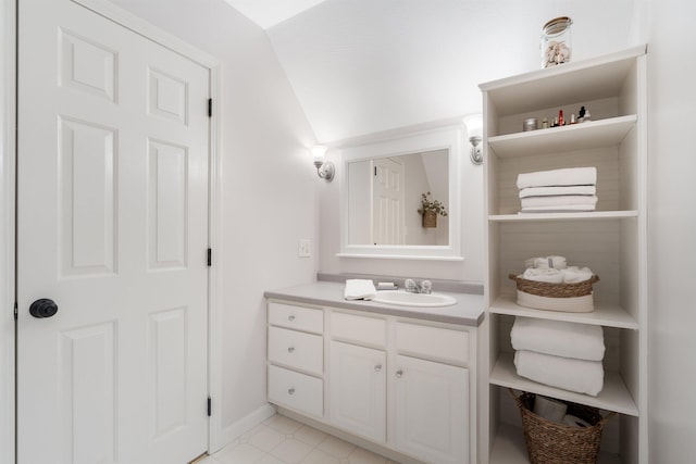 bathroom with vanity, baseboards, and vaulted ceiling