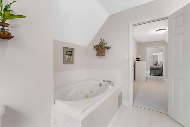 full bathroom with a tub with jets and lofted ceiling